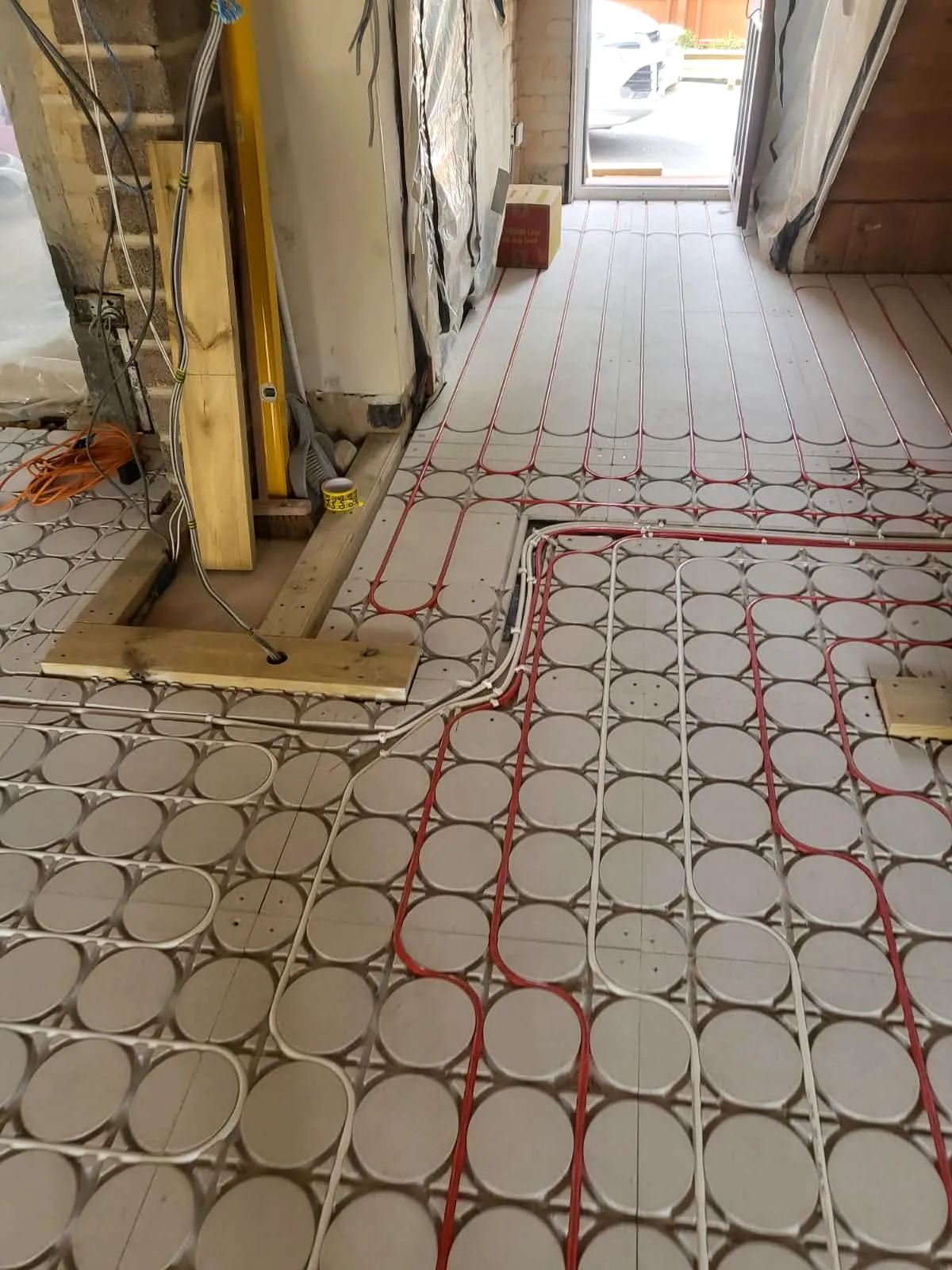 Narrow perspective of low-profile underfloor heating system laid across grooved insulation panels in Bournemouth home