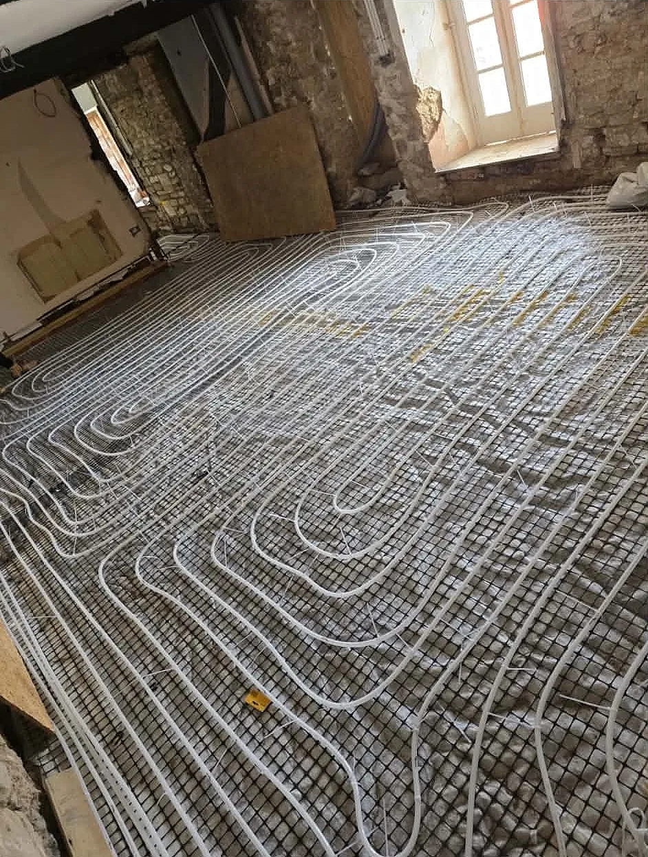 Interior view of cottage extension room fitted with wet mesh underfloor heating pipes prior to screed application