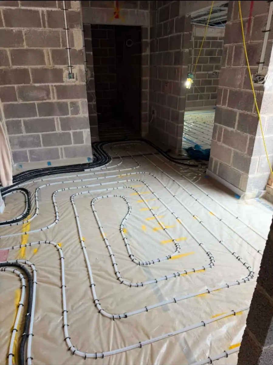 Interior view of a new build property at Oakwood Residence with wet underfloor heating pipes laid on floor insulation prior to screeding