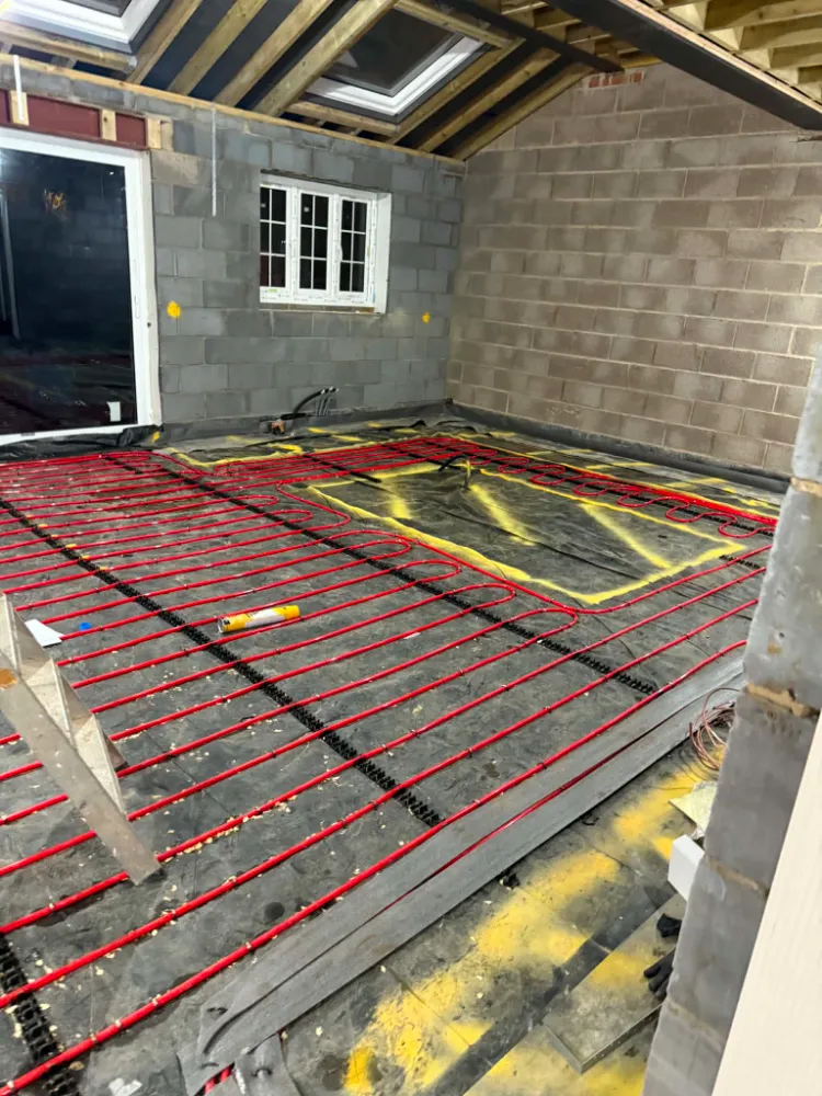 Wet underfloor heating pipe layout on insulation boards during construction phase at Willow Grove project